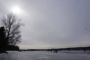 View of lake frozen with ice fishermen