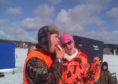 Man eating hotdog and lady laughing