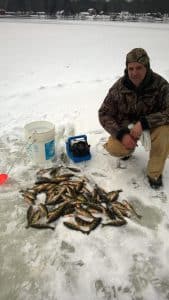 Man on ice with caught fish