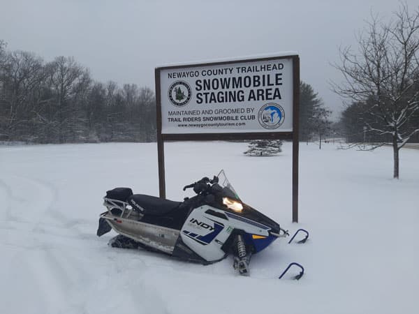 Snowmobile by Newaygo staging area sign