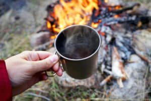 Cup of coffee by campfire