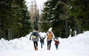 Family on walk through woods in winter
